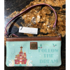 1 Disney Parks x Dooney & Bourke “Follow the Dream” wristlet front view featuring a castle and swans on mint background.