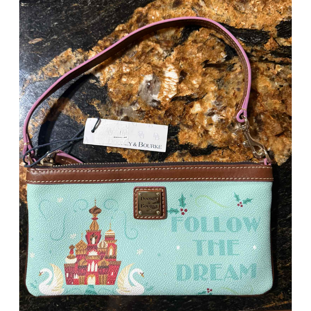 1 Disney Parks x Dooney & Bourke “Follow the Dream” wristlet front view featuring a castle and swans on mint background.