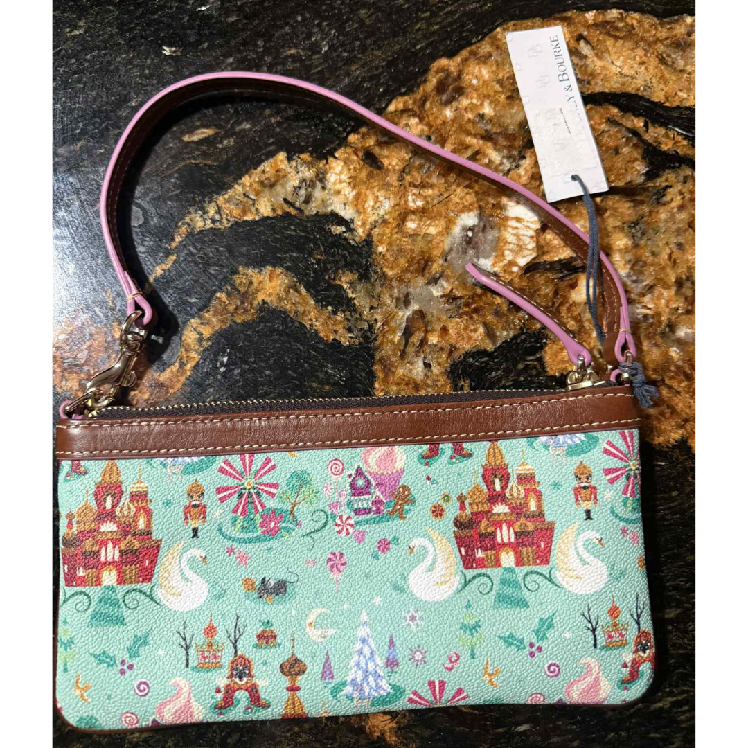 2 Back of Disney Parks x Dooney & Bourke “Follow the Dream” wristlet with Fantasyland-inspired pattern of castles, candy swirls, and swans.