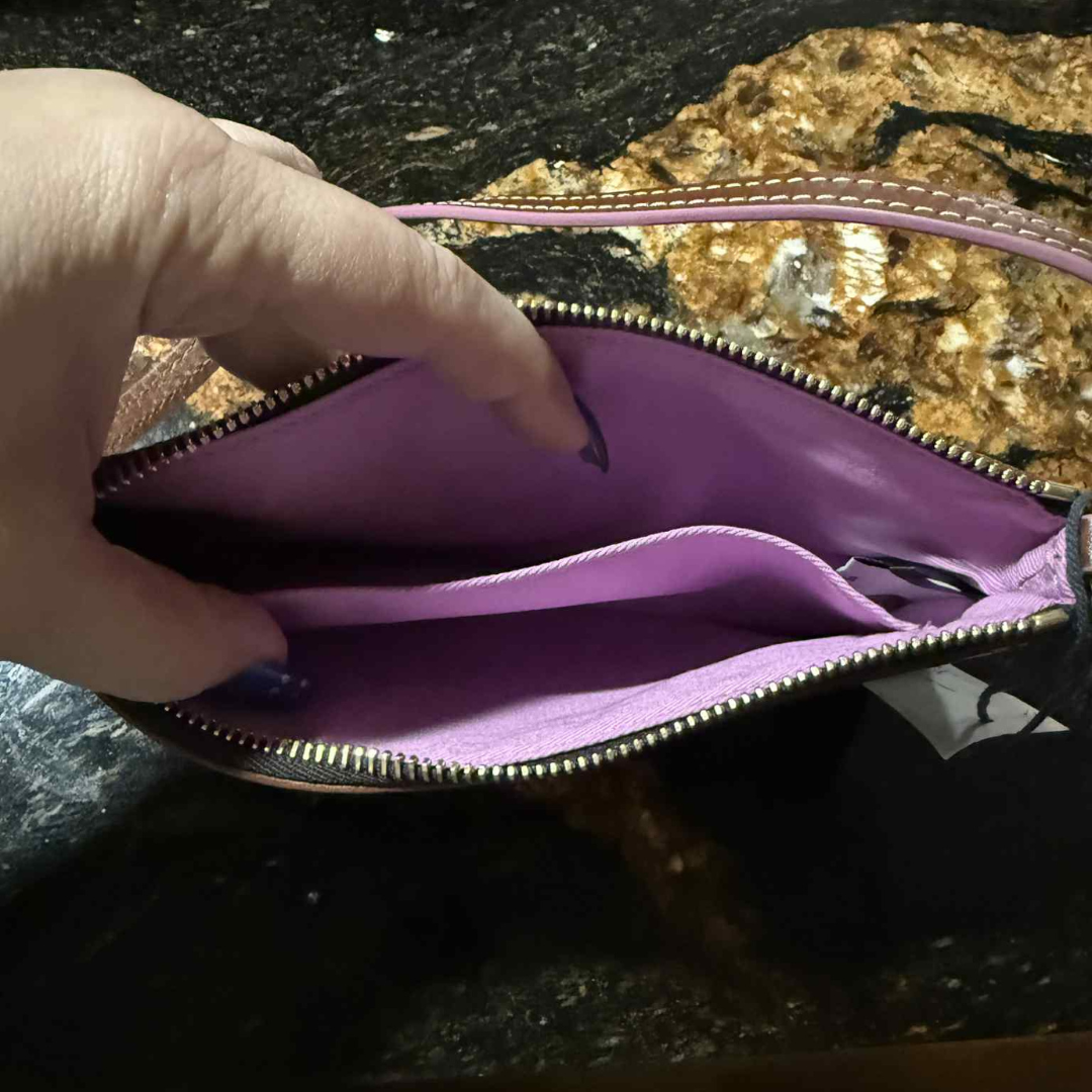 3 Interior of Disney Parks x Dooney & Bourke “Follow the Dream” wristlet showing lavender lining and slip pocket.