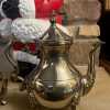 vintage-silverplate-coffee-pot-footed-ornate.jpg Vintage silverplated coffee pot with curved handle, ornate finial, and footed base.