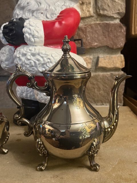 vintage-silverplate-coffee-pot-footed-ornate.jpg Vintage silverplated coffee pot with curved handle, ornate finial, and footed base.