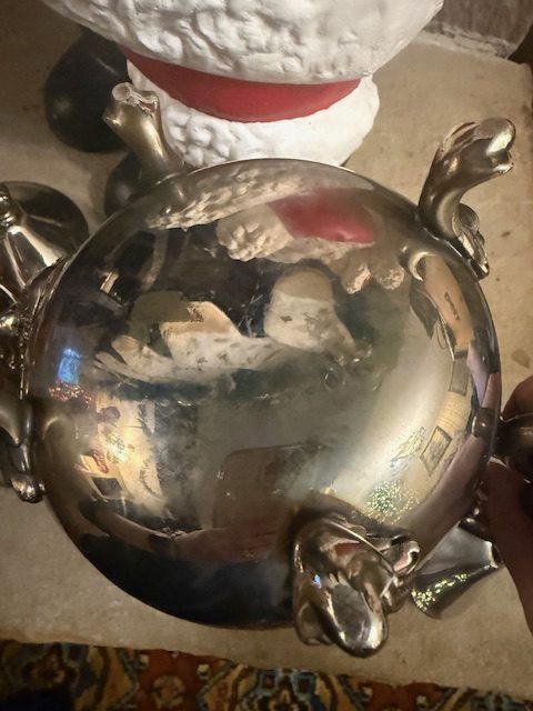 silverplate-coffee-pot-bottom-view-footed-design.jpg Bottom of the vintage silverplated coffee pot showing reflective finish and decorative feet.